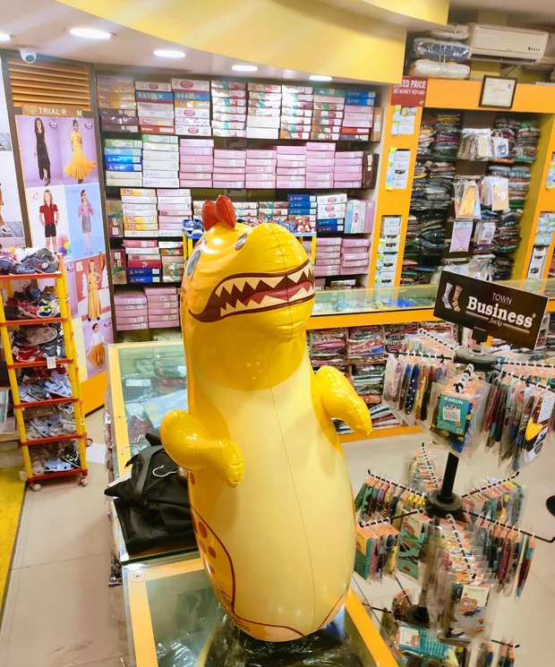 Kirnav Korner ground floor interior with cheerful yellow dinosaur mascot, trial rooms, and rows of boxed clothing